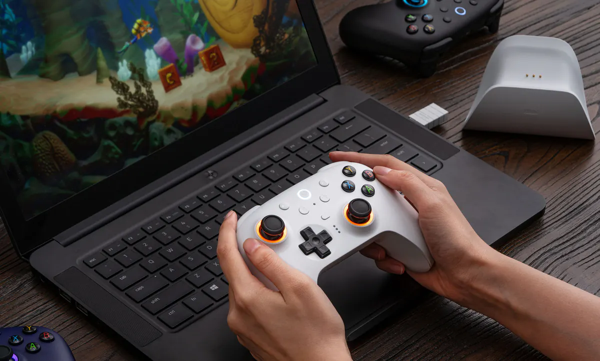 8BitDo Ultimate 2 Wireless Controller in use with a laptop game setup