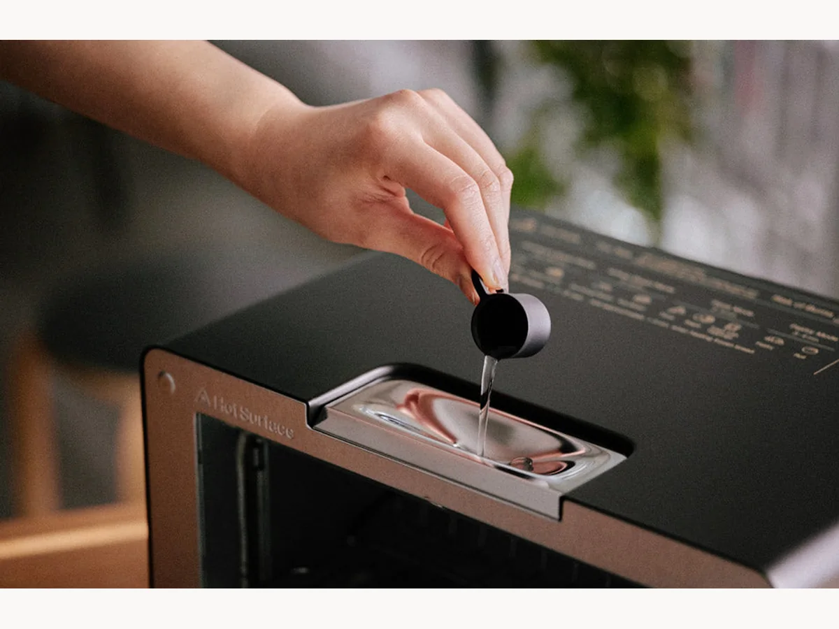 Person adding water to BALMUDA The Toaster Pro