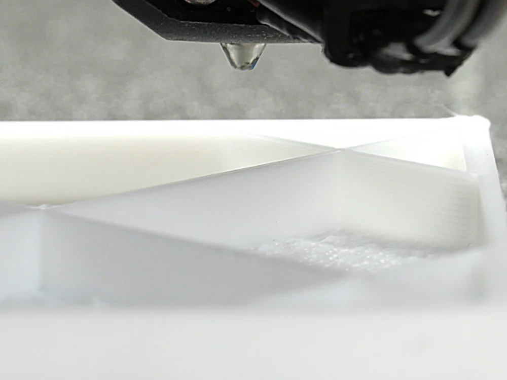Bambu Lab H2D close-up of the nozzle working on a white print