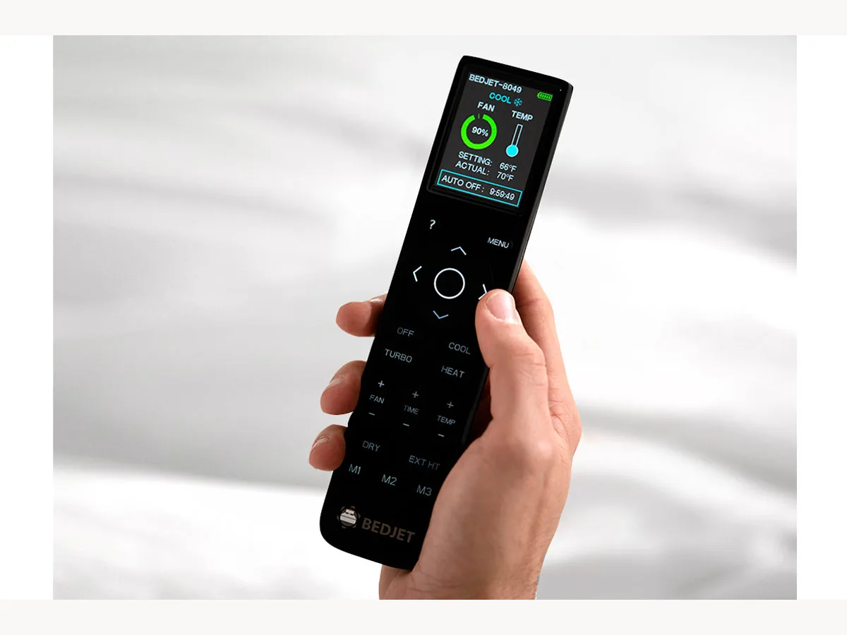 BedJet remote control held over bedding