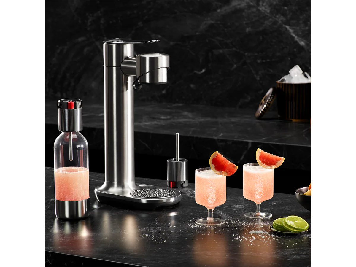 Breville InFizz Fusion on a dark bar counter with grapefruit drinks