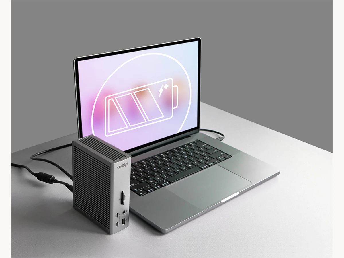 CalDigit Thunderbolt Station 4 standing beside a laptop while charging