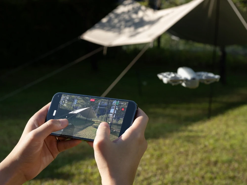 DJI Neo flying while controlled from a phone outdoors