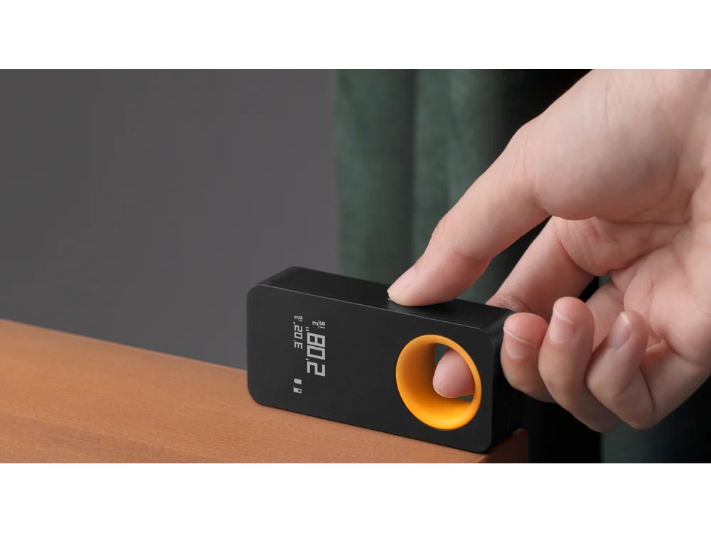 HOTO Laser Measuring Tool being used on a desk edge