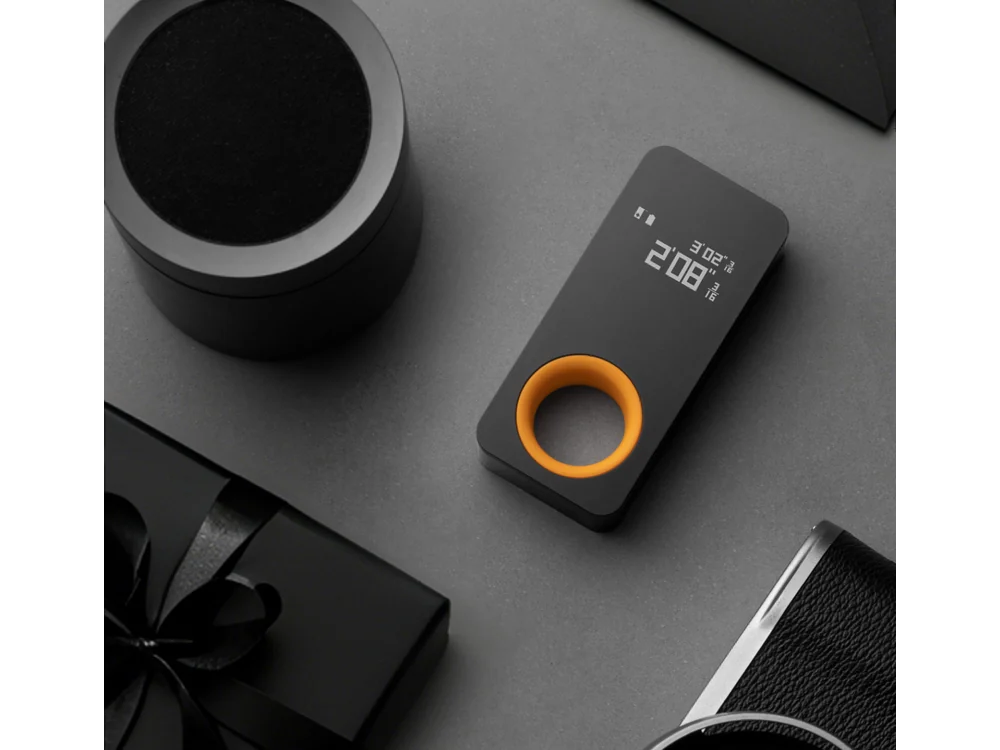 HOTO Laser Measuring Tool on a desk with everyday carry items