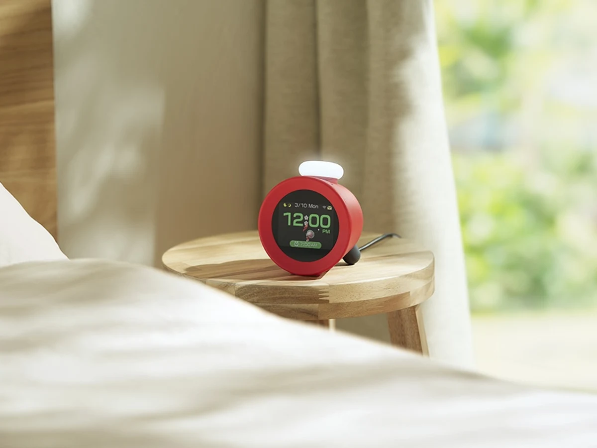 Nintendo Sound Clock Alarmo sitting on a nightstand beside a bed