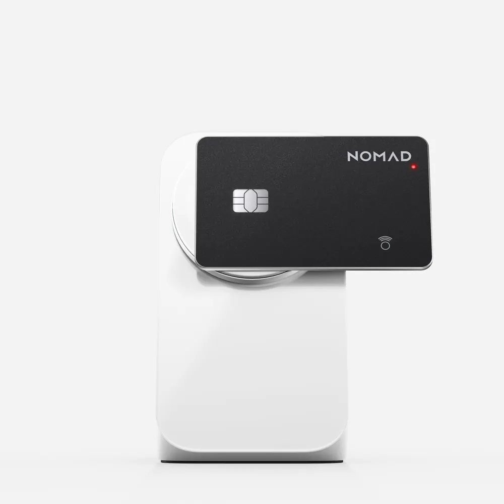 Nomad Tracking Card Pro charging on a white wireless charger