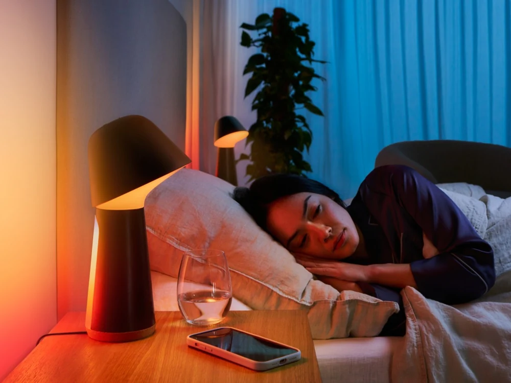 Person reading beside Philips Hue Twilight lamp before sleep