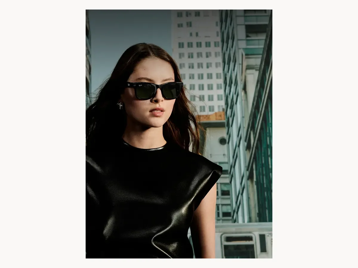 Woman wearing black Ray-Ban Meta smart glasses in a city setting