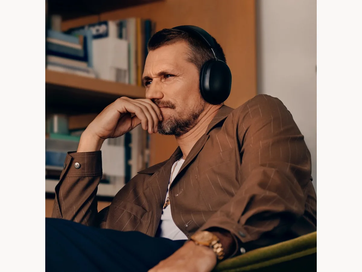 Person relaxing indoors while wearing black Sonos Ace headphones