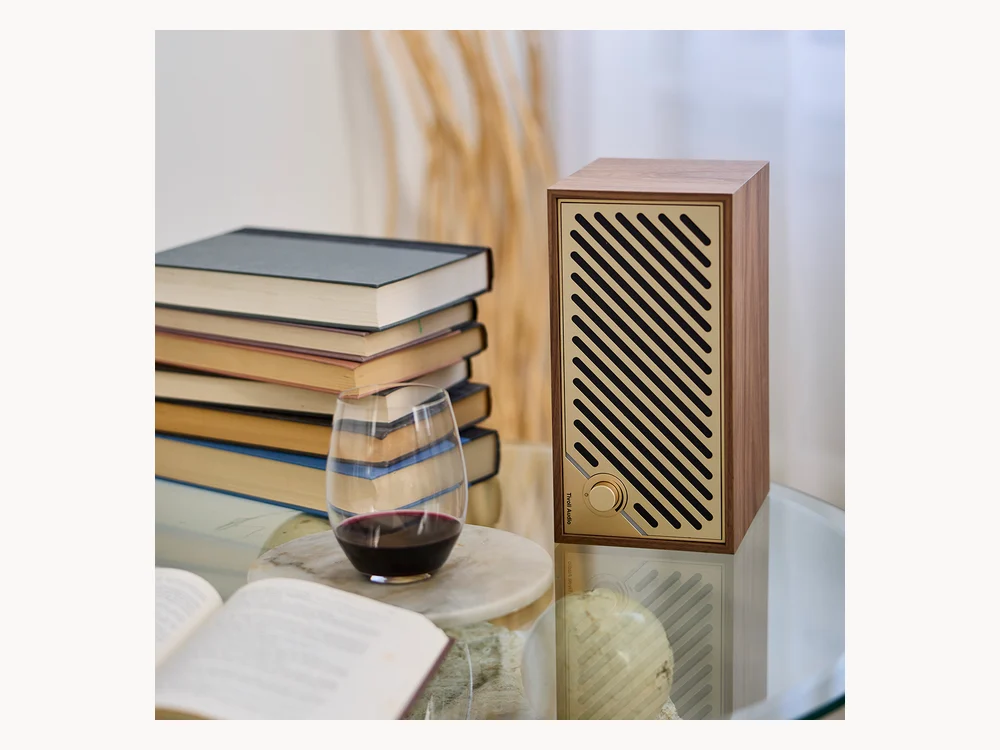 Tivoli Audio Model Two Digital speaker in a home setting with books and wine