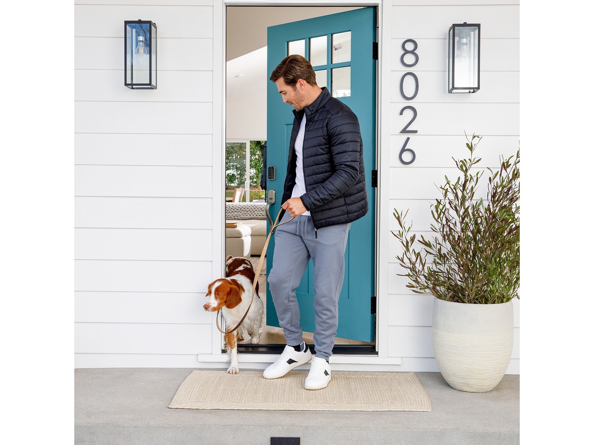Person arriving home with dog at a front door using Yale Assure Lock 2