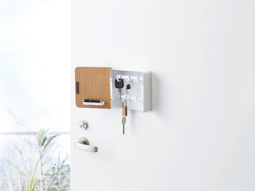 Yamazaki Home Rin Magnetic Key Cabinet open on a white entry door with keys inside